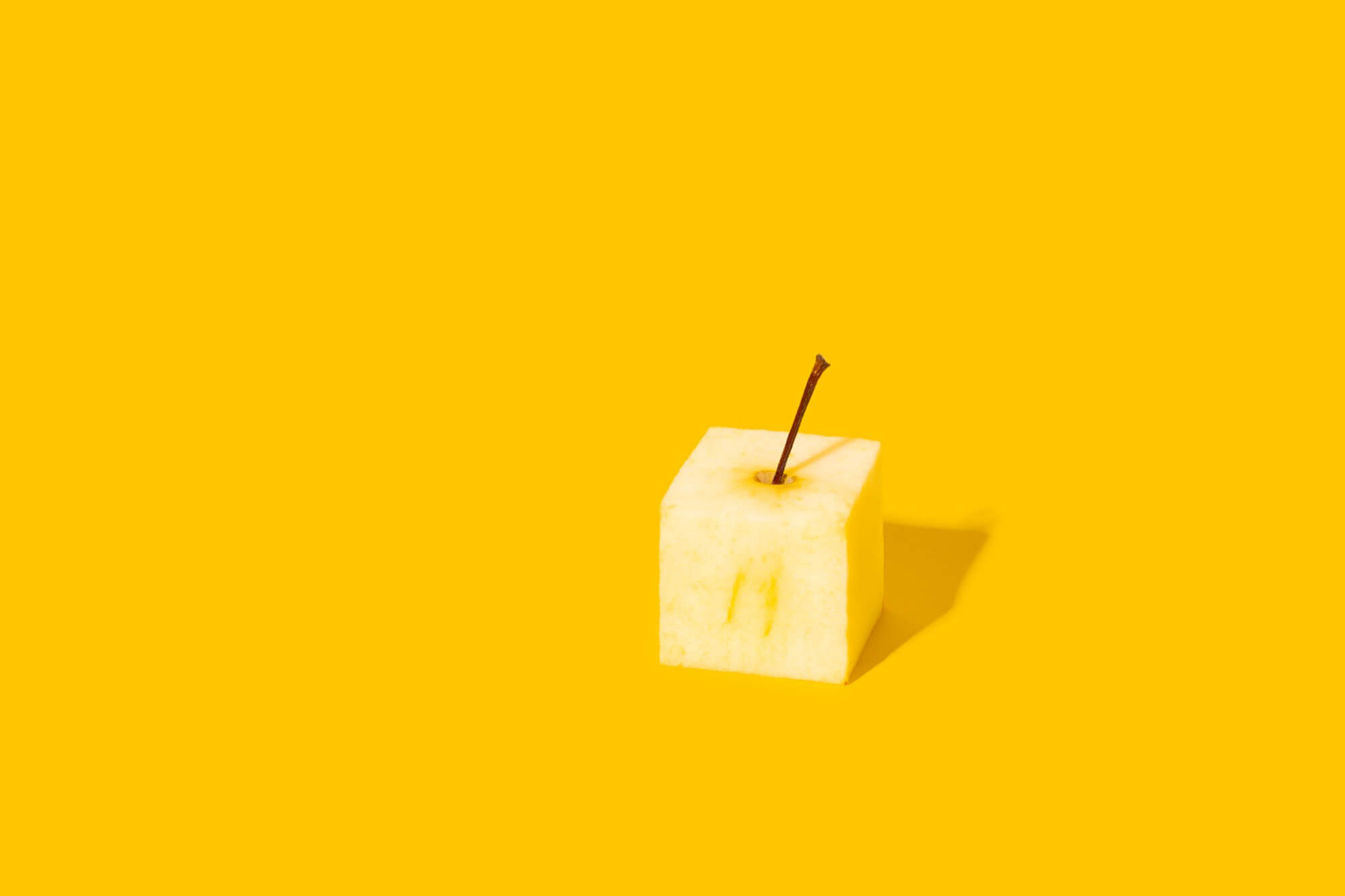 Concept of creativity and innovative ideas. Square apple on yellow background.