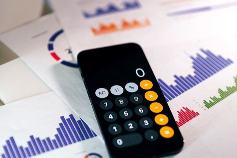 smartphone calculator app on financial report papers